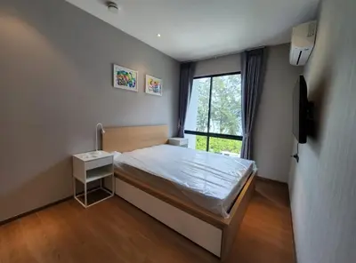 a bedroom with a large bed and a window at The Title Seaview Apartment in Phuket Town