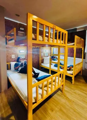 a room with three bunk beds with a woman laying on them at Frutta Hostel in Patong Beach