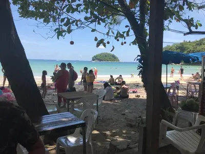 a group of people sitting on the beach at Little Mermaid Guesthouse & Restaurant in Kata Beach