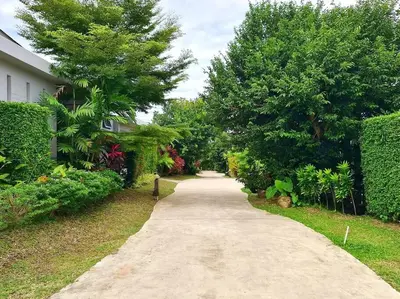 a long path in a yard with trees and a house at Villa Mimosa 3, Luxury 4Bedroom Private Pool-Rawai in Kata Beach