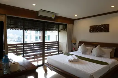 a bedroom with a large bed and a large window at Best Venue Hotel in Patong Beach