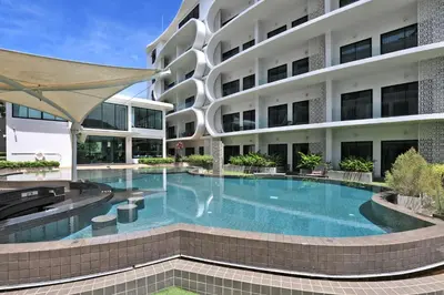 a swimming pool in front of a building at 1 bdr apartment in Utopia Naiharn by Capital pro in Phuket Town