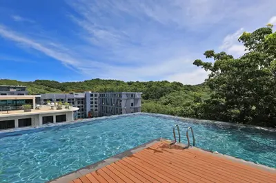 a large swimming pool on top of a building at 1 bdr apartment in Utopia Naiharn by Capital pro in Phuket Town