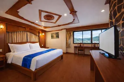 a bedroom with a bed and a flat screen tv at Tiger Complex Hotel in Patong Beach