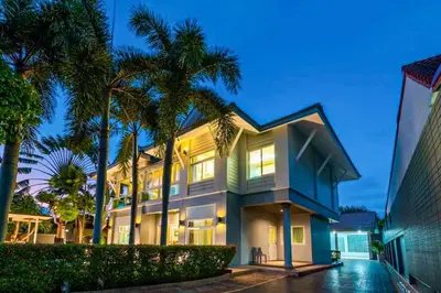 a large house with palm trees in front of it at Poolvillapanwa in Panwa Beach