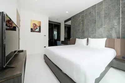 a bedroom with a large white bed and a wall at Scenic Seaview 270 Panorama, 2BR Penthouse VV Patong C701 in Patong Beach
