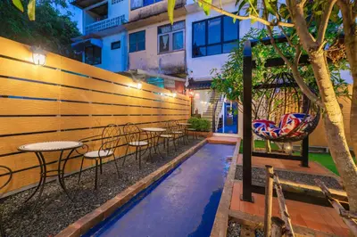 a row of tables and chairs next to a fence at Marco Polo Phuket Poshtel & Bistro in Phuket Town