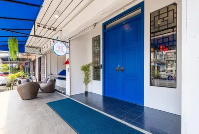 a blue door on a building with a blue rug at Marco Polo Phuket Poshtel & Bistro in Phuket Town