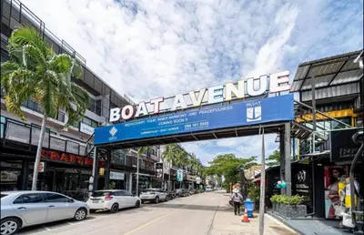 a sign over a street with cars parked at Cozy 1 bedroom in prime Bangtao in Bang Tao Beach