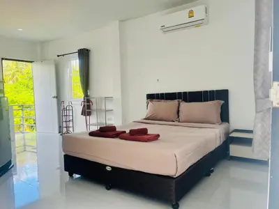 a bedroom with a large bed with red pillows on it at Rest Mind House in Surin Beach