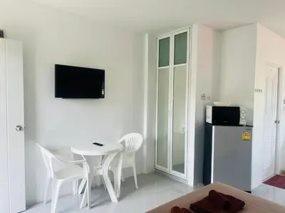 a white room with a table and chairs and a refrigerator at Rest Mind House in Surin Beach