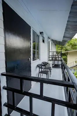 a balcony with tables and chairs on a house at The Bright House, Koh Phi Phi in Phi Phi Don