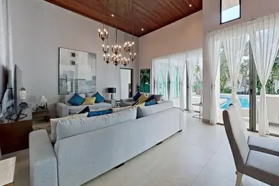 a living room with a large couch and a pool at Mandala by Villacarte in Bang Tao Beach