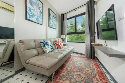 a living room with a couch and two windows at Zcape1 apartment at Boat Avenue by Lofty in Bang Tao Beach