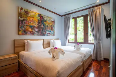a bedroom with a bed with two stuffed elephants on it at Luxury Sai Taan Villa in Bang Tao in Bang Tao Beach