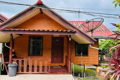 a small wooden house with a porch and a door at Lamsai AC Sea House in Ko Yao Noi