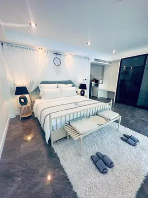 a large bedroom with a large white bed and a rug at Ocean Pie Phuket - Adult Only in Rawai Beach