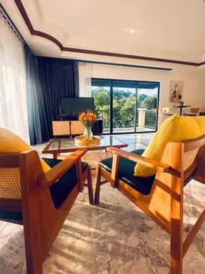 a living room with a wooden table and chairs at Ocean Pie Phuket - Adult Only in Rawai Beach