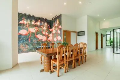 a dining room with a large painting of pink flamingos at The Lunar Patong in Patong Beach
