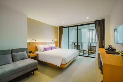 a hotel room with a bed and a couch at The Lunar Patong in Patong Beach