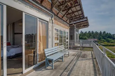 a porch with a bench and a bed on it at Artisan koh yao yai handcraft beachfront villas. in Ban Lo Pa Ret