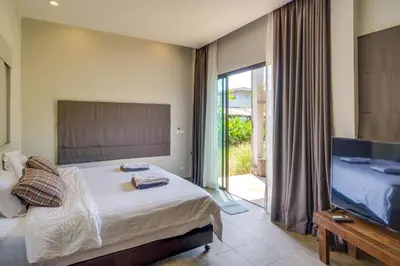 a bedroom with a large bed and a television at Artisan koh yao yai handcraft beachfront villas. in Ban Lo Pa Ret