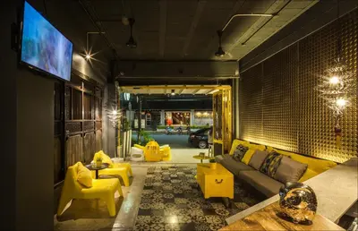 a living room with a couch and yellow chairs at Fulfill Phuket - SHA in Phuket Town
