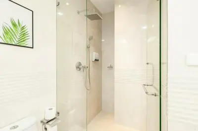 a shower with a glass door in a bathroom at Rudi Condo by Q Conzept in Kata Beach