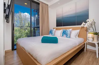 a bedroom with a large bed with a large window at Apartment in laguna , 600 metres from the beach in Phuket Town