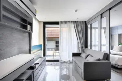 a living room with a couch and a bed at City Gate Kamala D209 by Phuket Sabay Rent in Phuket Town