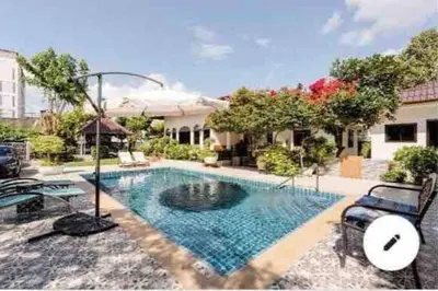 a swimming pool in front of a house at Summer House,shared pool, private bathroom and kitchen in Ban Phlu Yai