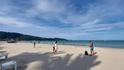 a group of people standing on a beach at Sawasdee Apartment Patong in Patong Beach