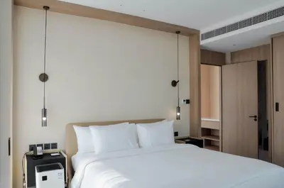 a bedroom with a large white bed and a closet at Laya Resort Phuket in Layan Beach