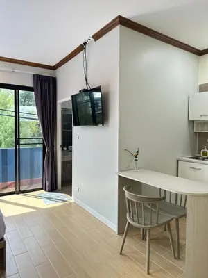 a kitchen with a table and a television on a wall at Kata Noi Place floor3 in Kata Beach
