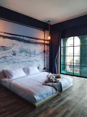 a bedroom with a large bed with a painting on the wall at W168 hostel in Ban Lo Long