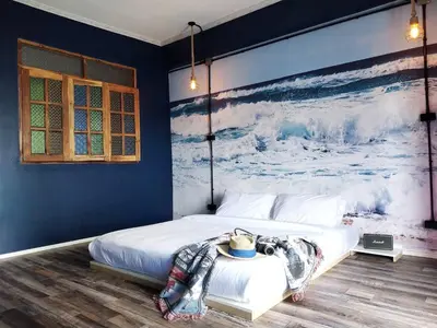 a bedroom with a bed with a painting on the wall at W168 hostel in Ban Lo Long
