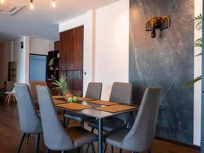 a dining room with a wooden table and chairs at Grand Penthouse by Grand Orlov Apart in Patong Beach