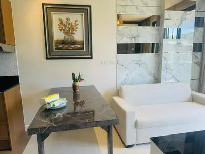 a living room with a table and a white couch at 2 bed room the lago naiharn beach in Nai Harn Beach