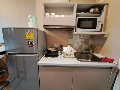 a small kitchen with a refrigerator and a microwave at Zcape1 boat avenue in Ban Thalat Choeng Thale