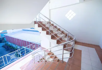 a spiral staircase in a building with a pool at G house guest house in Patong Beach