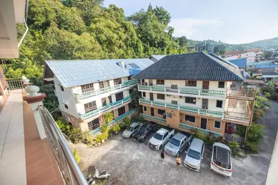 an aerial view of a building with cars parked in a parking lot at G house guest house in Patong Beach