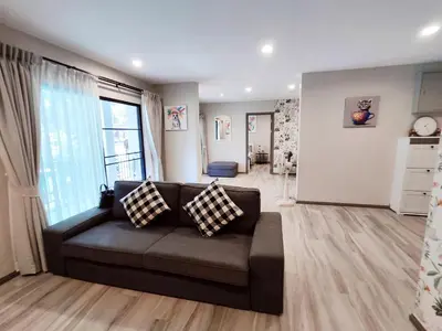 a living room with a couch and a large window at 2 Bedrooms Suite Pool Access@The Title Residencies Naiyang in Nai Yang Beach
