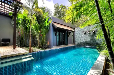 a swimming pool in front of a house with trees at Villa Casablanca in Ban Saiyuan (1)