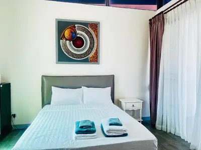 a bedroom with a bed with two towels on it at Townhouse in the Wonderland in Bang Tao Beach