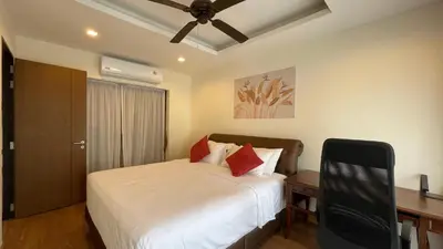a bedroom with a bed with a ceiling fan at Townhouse in the Wonderland in Bang Tao Beach