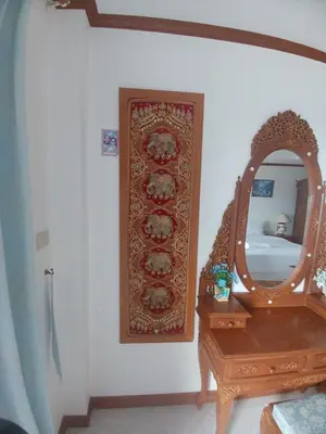 a mirror on a wall next to a wooden table at Aksarai hotel in Patong Beach