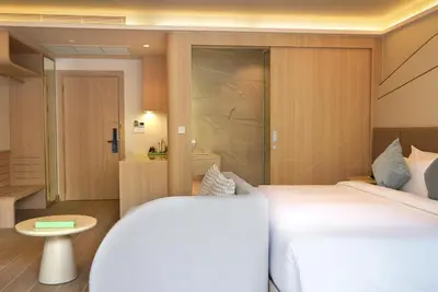 a hotel room with two beds and a bathroom at Wyndham Garden Naithon Phuket in Nai Thon Beach