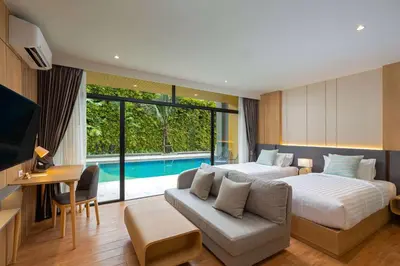a bedroom with two beds and a couch and a pool at Wyndham Garden Naithon Phuket in Nai Thon Beach