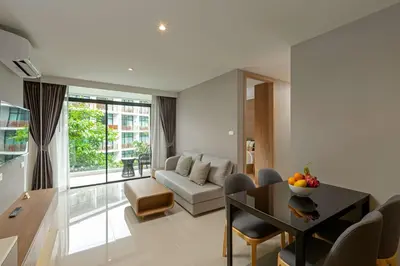 a living room with a couch and a table at Wyndham Garden Naithon Phuket in Nai Thon Beach
