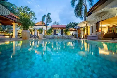 a swimming pool in a resort with umbrellas at Saitaan,4BR seaside garden pool villa, Laguna area in Bang Tao Beach